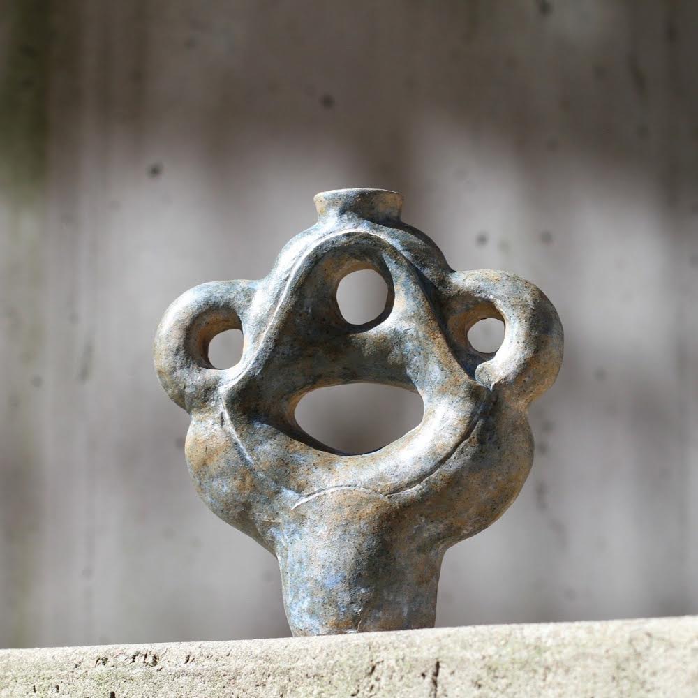 Orange salt-fired clay ikebana vase, a circular disc-like vessel with small hole for flower arrangements